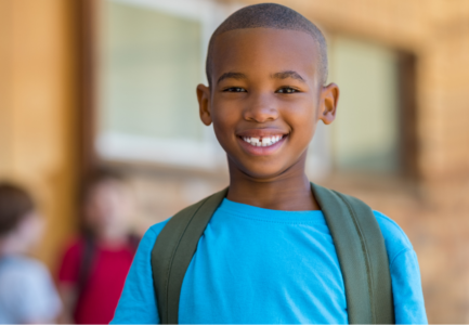 black boy in blue shirt with backpack